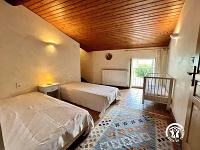 a bedroom with two beds and a wooden ceiling at Domaine de la calm in Villardonnel