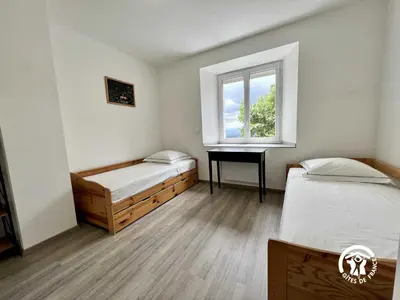 a bedroom with two beds and a window and a desk at La calm in Villardonnel