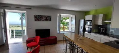 a kitchen with a counter and red chairs in a room at La calm in Villardonnel