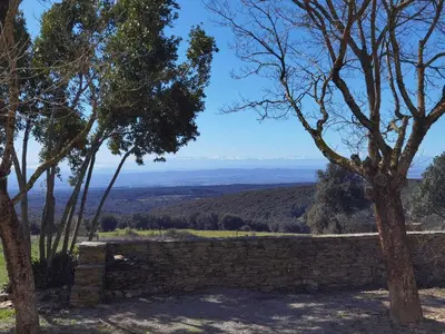 a stone wall with a view of the mountains at La calm in Villardonnel