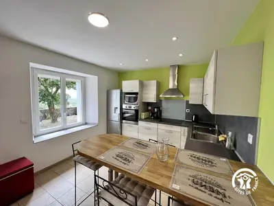a kitchen with a wooden table and a counter top at La calm in Villardonnel