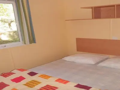 a bedroom with a bed and a window at Mobil home 21m² avec terrasse à Axat - API-1-52-1082 in Axat