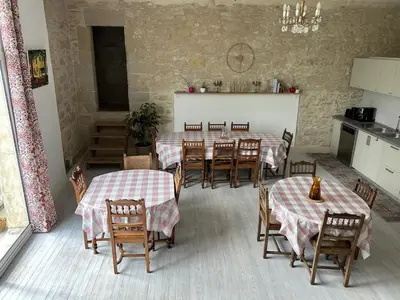 a dining room with tables and chairs and a kitchen at Soupex Castle century XII in Soupex