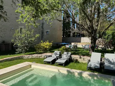 a swimming pool with chairs and a table and a tree at Soupex Castle century XII in Soupex