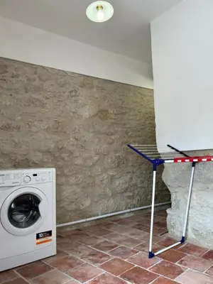 a washing machine and a table in a room at Soupex Castle century XII in Soupex