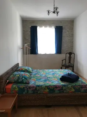 a bedroom with a bed and a window with blue curtains at Soupex Castle century XII in Soupex
