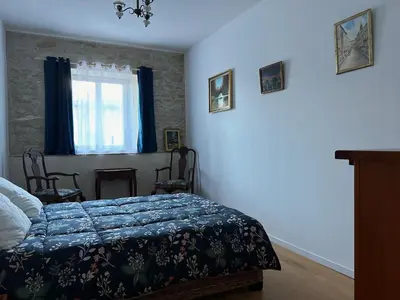 a bedroom with a bed with a blue comforter and a window at Soupex Castle century XII in Soupex