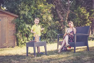 a young boy and a woman sitting on chairs in a yard at 514 Appart Hotel in Carcassonne