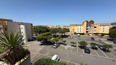 an aerial view of a parking lot with cars at AIG168 GRUISSAN STUDIO VUE PORT AVEC TERRASSE PARKING ET PISCINES in Gruissan