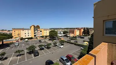 a view of a parking lot with cars parked at AIG168 GRUISSAN STUDIO VUE PORT AVEC TERRASSE PARKING ET PISCINES in Gruissan