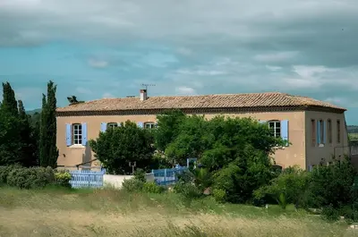 a house with a blue fence in front of it at Chambre Dora - Relais de l'Alaric in Moux