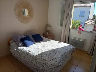a bedroom with a bed with blue pillows and a window at Maison avec beaucoup de caractères in Bages
