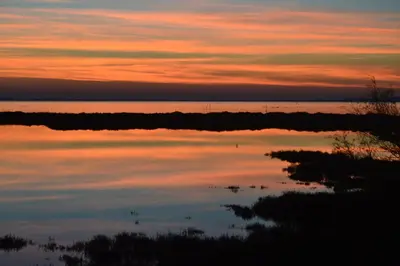 a reflection of a sunset in a body of water at Maison avec beaucoup de caractères in Bages