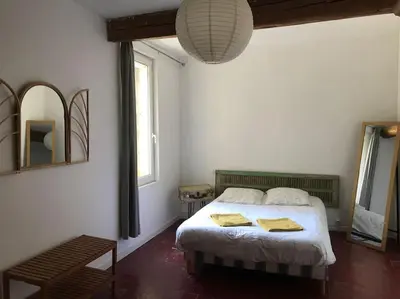 a bedroom with a bed with two towels on it at Gîte Narbonne 15 personnes in Narbonne
