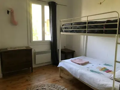 a bedroom with a bunk bed and a window at Gîte Narbonne 15 personnes in Narbonne