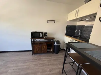 a kitchen with a tv on a table in a room at Studio 17 m2 avec piscine et parking - Gruissan in Gruissan