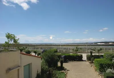 a view of a building with a walkway and bushes at Studio 17 m2 avec piscine et parking - Gruissan in Gruissan