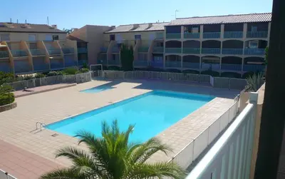 a large swimming pool in front of a building at Studio 17 m2 avec piscine et parking - Gruissan in Gruissan