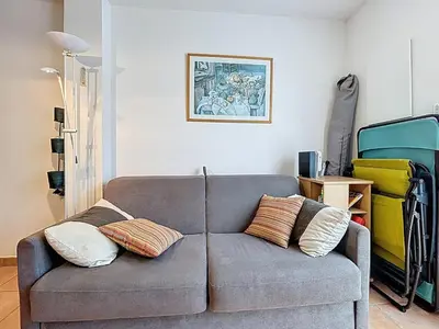 a living room with a gray couch with two pillows at Villa Closia - Maison de vacances à 50mètres de la plage - Climatisation et Wifi in Gruissan