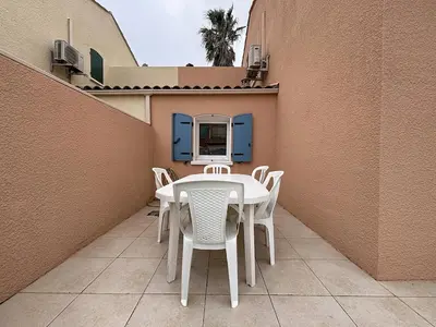a table and chairs on the balcony of a building at Villa Closia - Maison de vacances à 50mètres de la plage - Climatisation et Wifi in Gruissan