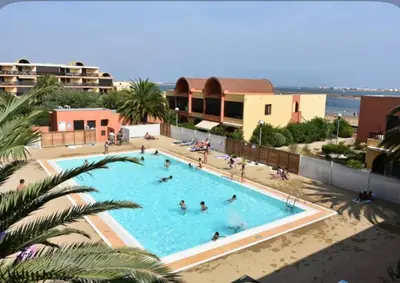an overhead view of a swimming pool with people in it at Studio chaleureux en bord de mer in Gruissan