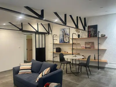 a living room with a blue couch and a table at Résidence des catalans in Narbonne