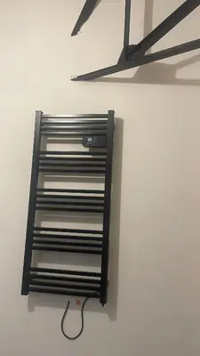 a metal shelf on a wall with a wire at Résidence des catalans in Narbonne