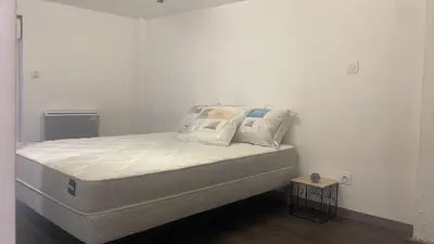 a bed with white sheets and pillows in a room at Résidence des catalans in Narbonne