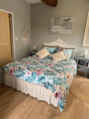 a bedroom with a bed with a colorful blanket at L'écrin vert in Villelongue-dʼAude