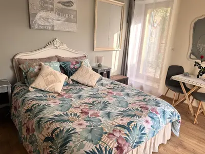 a bedroom with a bed with a floral bedspread at L'écrin vert in Villelongue-dʼAude