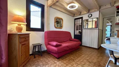 a living room with a red chair and a sink at Pavillon avec piscine collective proche Grazel - GN020-001 in Gruissan