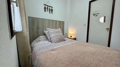 a bedroom with a bed with a wooden head board at Pavillon avec piscine collective proche Grazel - GN020-001 in Gruissan