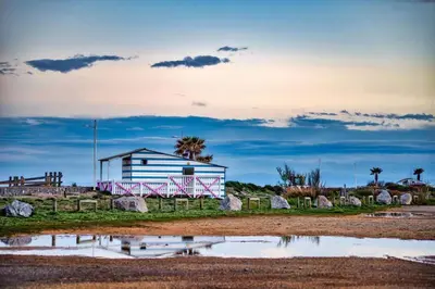 a house on the beach with a reflection in the water at Pavillon avec piscine collective proche Grazel - GN020-001 in Gruissan