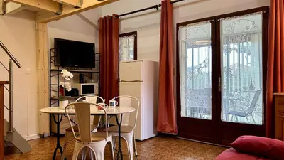 a kitchen with a table with chairs and a refrigerator at Pavillon avec piscine collective proche Grazel - GN020-001 in Gruissan