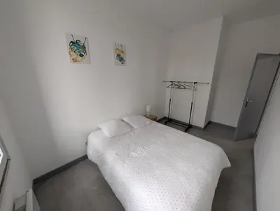 a white bedroom with a bed with a white blanket at Agréable appartement 65 m2 type 3 Narbonne centre-ville in Narbonne