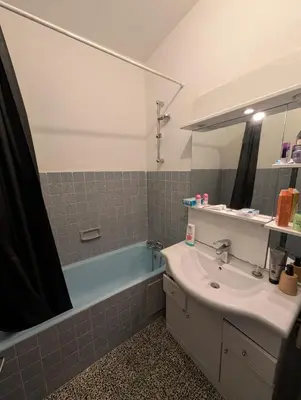 a bathroom with a sink and a blue bath tub at Agréable appartement 65 m2 type 3 Narbonne centre-ville in Narbonne