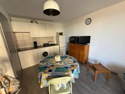 a kitchen with a table and a kitchen with a table and a refrigerator at AIG 52 – Appartement en rez-de-chaussée – Résidence de la Plage – Gruissan – 4 personnes in Gruissan