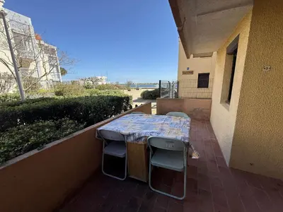 a table and chairs on the balcony of a building at AIG 52 – Appartement en rez-de-chaussée – Résidence de la Plage – Gruissan – 4 personnes in Gruissan