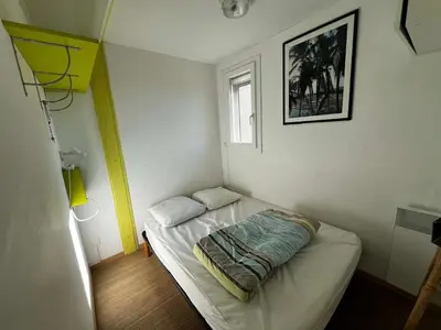 a small bed in a room with a window at AIG 59 – Studio avec 2 cabines – Résidence Grand Sud – Gruissan – 4 personnes in Gruissan
