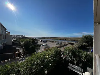 a view of a parking lot next to the ocean at AIG 59 – Studio avec 2 cabines – Résidence Grand Sud – Gruissan – 4 personnes in Gruissan
