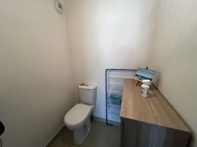a bathroom with a toilet and a wooden counter at AIG 84 – Appartement T3 – Résidence Ephyra – Gruissan – 4 personnes in Gruissan