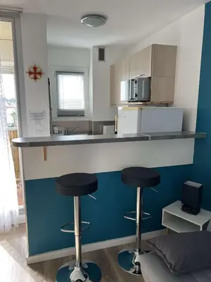a kitchen with two bar stools and a counter top at AIG_183 Studio rénové avec terrasse et vue exceptionnelle sur la marina, l’étang et le village de Gruissan in Gruissan
