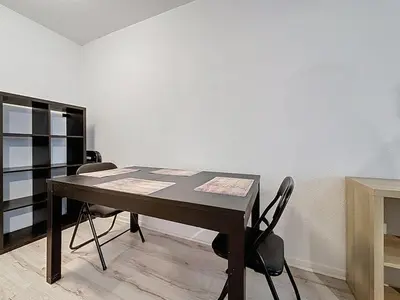 a table and chairs in a room with a white wall at Le Garibaldi - Appartement proche du centre - Wi-Fi in Narbonne