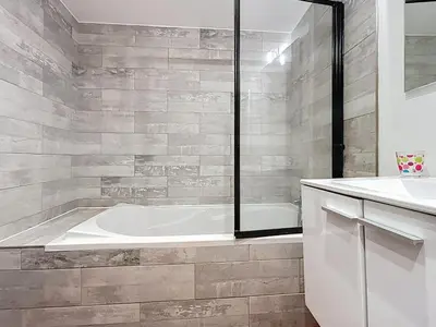 a white bathroom with a tub and a sink at Le Garibaldi - Appartement proche du centre - Wi-Fi in Narbonne