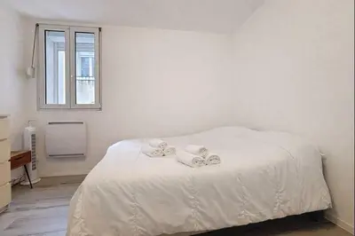 a bedroom with a white bed with towels on it at Le Garibaldi - Appartement proche du centre - Wi-Fi in Narbonne