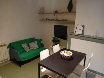 a living room with a green couch and a table at Le Damier in Quillan