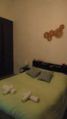 a bed with three pillows on top of it at Le Damier in Quillan
