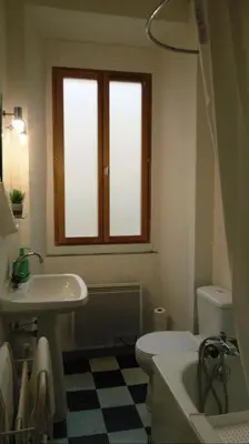 a bathroom with a sink and a toilet and a window at Le Damier in Quillan