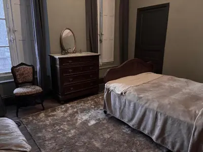 a bedroom with a bed and a dresser and a mirror at La Maison Jolie bnb in Puicheric