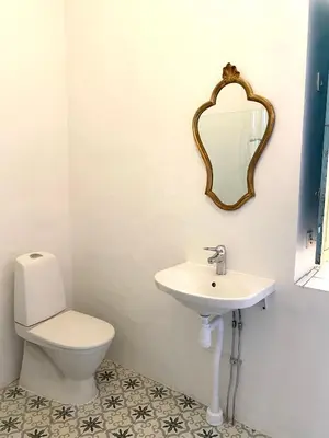 a bathroom with a toilet and a sink and a mirror at La Maison Jolie bnb in Puicheric